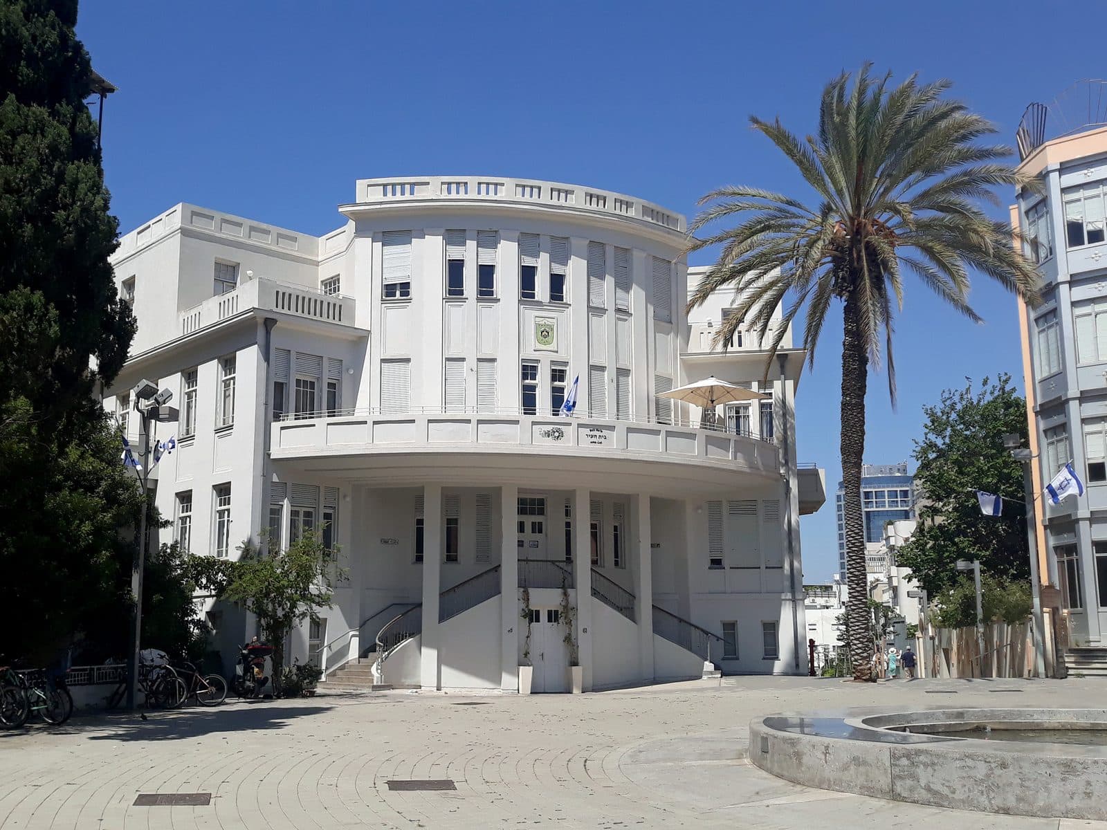 בית העיר בכיכר ביאליק, תל אביב: בניין לבן ודקל גבוה מול שמיים כחולים
